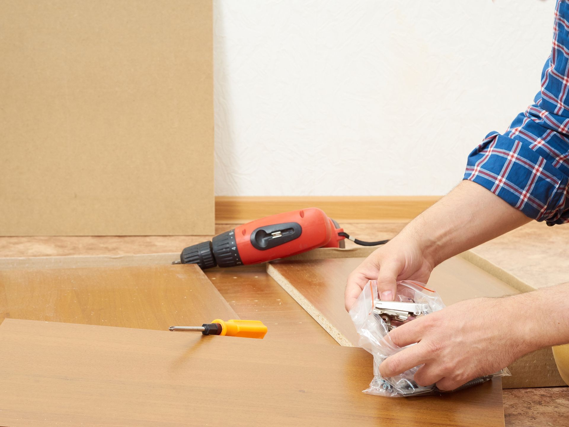 Man in shirt assemble furniture. Domestic work. Craftsman. Carpenter.  